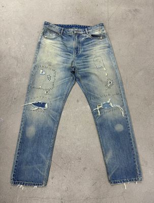 Bajo de denim de lavado ligero con pesado estresante para un aspecto vintage robusto