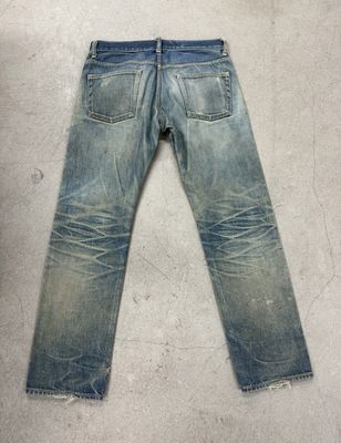 Jeans de lavado ligero con desvanecimiento pesado y bigotes para un aspecto vintage robusto