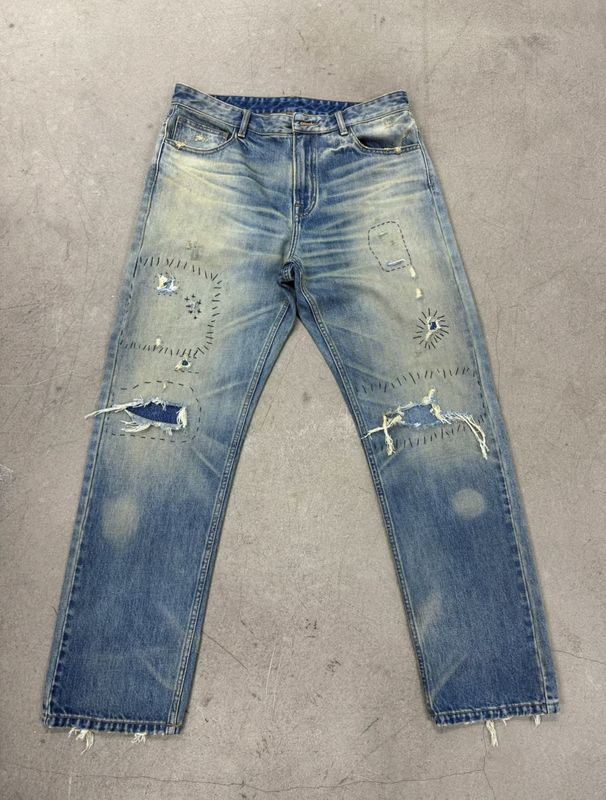 Bajo de denim de lavado ligero con pesado estresante para un aspecto vintage robusto