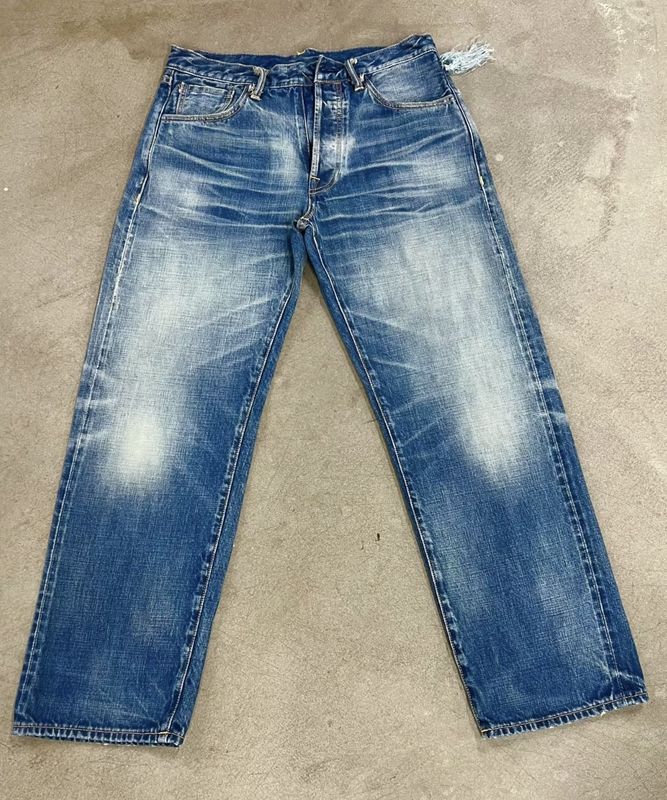 Bajo de denim de lavado ligero con sutil desvanecimiento y bigotes para un aspecto clásico