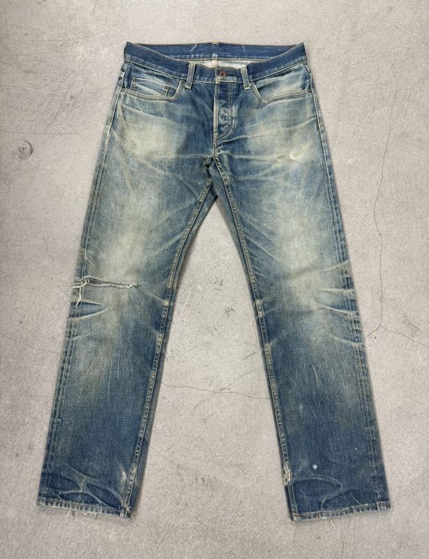 Jeans de lavado ligero con desvanecimiento pesado y bigotes para un aspecto vintage robusto